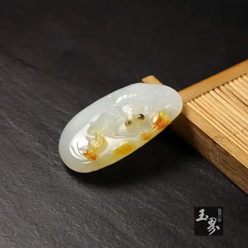 和田玉雕刻鱼与荷花寓意干的体裁,展现自然和谐之美