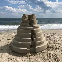 他用沙子在海滩上建了一座座海景房
